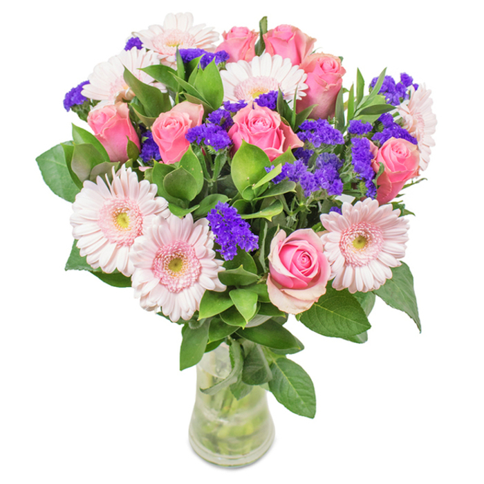 A vibrant floral bouquet, meticulously arranged in a transparent vase, stands against a crisp white background-an elegant reflection of Hampton's riverside grace. The design features about 7-9 roses in soft, delicate pinks, their classic spiraled petals either just beginning to open or still securely encased, exuding timeless beauty. Interspersed are 5-7 pale pink gerbera daisies, their large heads and radiating petals reminiscent of morning sunshine on Hampton Green, each with a lighter center that seems to sparkle in the light. Throughout the bouquet, radiant purple statice-or Limonium-adds depth and a striking contrast, its textured florets echoing the wild blooms found near the riverbanks. The arrangement's base is framed by abundant, glossy green foliage, enhancing a sense of freshness and natural vibrancy central to Hampton living. The clear glass vase reveals clean, clipped stems immersed in fresh water, completing the portrait of a bouquet ready for same-day delivery to local homes, offices, or celebratory events. Suitable for birthdays, anniversaries, Mother's Day, or simply as a thoughtful gift, this arrangement from Florist Hampton exudes joy, warmth, and the affection characteristic of our community.